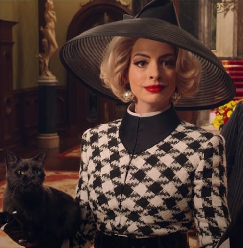 Anne Hathaway dressed in a black and white houndstooth suit with a black hat and pearl earrings. Ver...