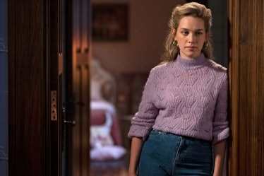 Dani, from "Bly Manor," standing in a doorway in mom jeans and a purple sweater.