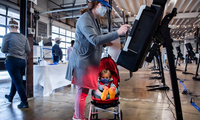 A voter and her daughter fill out a ballot in a Super Vote Center at Union Market during early votin...