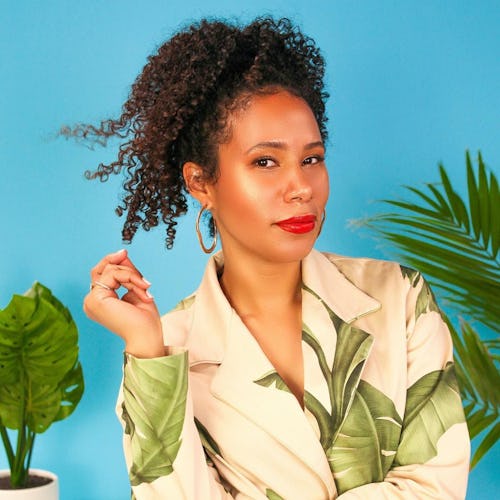Lulu Cordero, the founder of the Afro-Latinx brand Bomba Curls posing in a suit with banana leaves p...