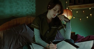 Bella Swan, played by Kristen Stewart, doing homework while on the phone with her mom.