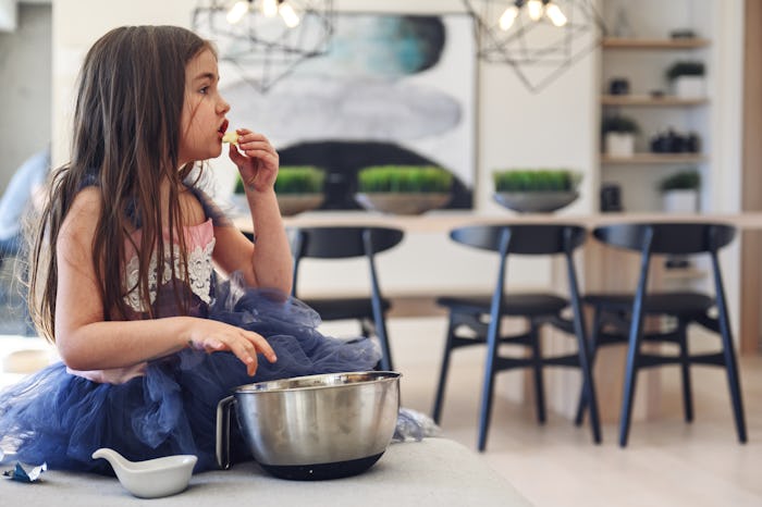 young girl watching movies/tv in princess costume eating popcorn