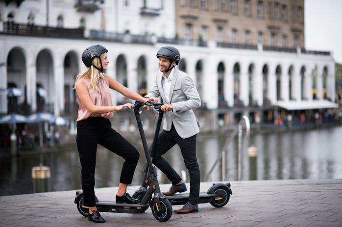 A man and a woman on Segway Ninebot Kickscooter MAXs.