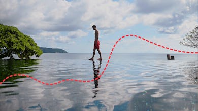A man walking on an edge of an infinity pool during his Thailand honeymoon