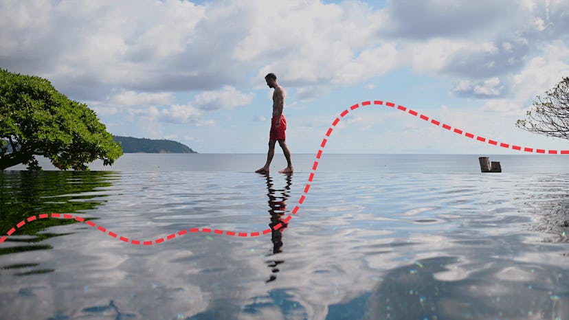 A man walking on an edge of an infinity pool during his Thailand honeymoon