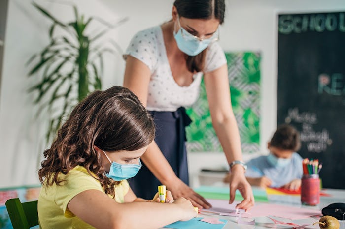 paraprofessional helping kid with school