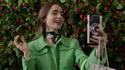 Emily (Lily Collins) takes a selfie with a berry. 