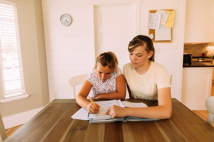 tutor and kid working at table