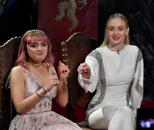 Maisie Williams wearing a pink dress with pink hair and sophie turner in a white dress with red lips...