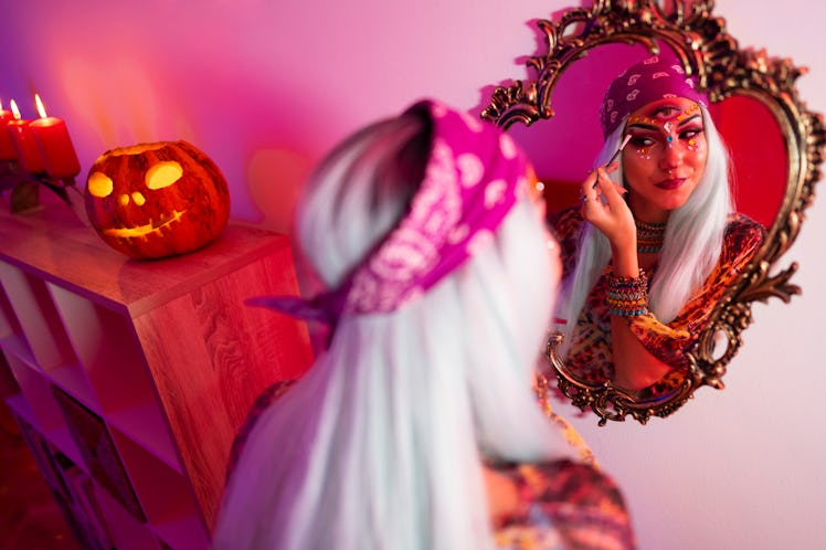 Young woman doing Halloween makeup