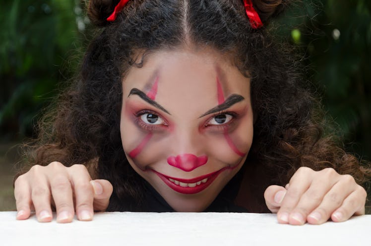 Young woman in evil clown makeup