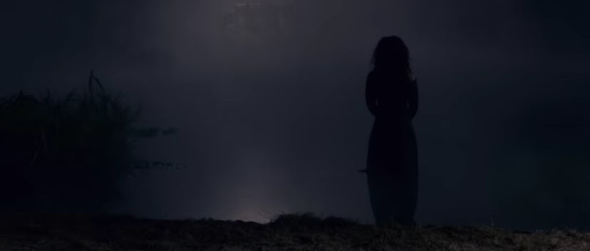 Miss Jessel's ghost standing by the lake in  'The Haunting of Bly Manor'