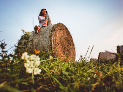 Young woman with hay bale