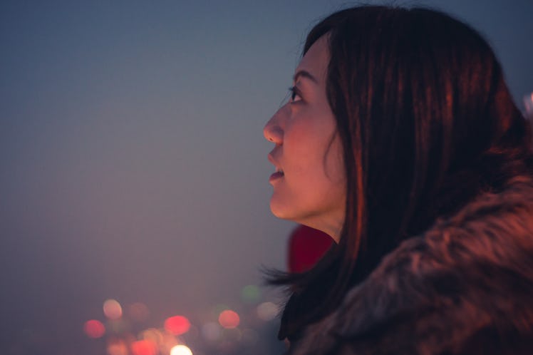 Young woman looking up at night sky