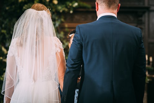 A picture of a person in a wedding dress and a person in a suit, holding hands at the alter