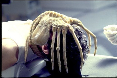 A facehugger from the movie 'Alien' attacking a person's face.