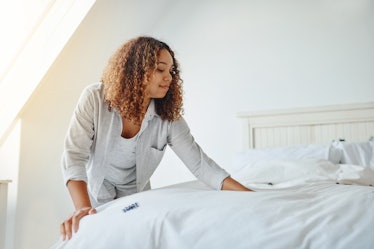 Young woman making her bed