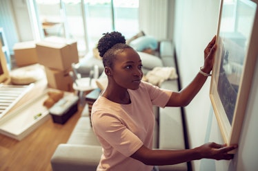 Young woman hanging painting