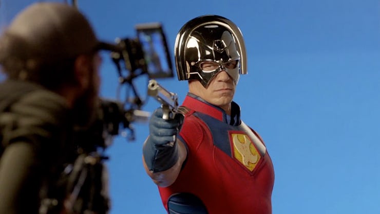 John Cena as the DC character called Peacemaker holding a gun on the set 