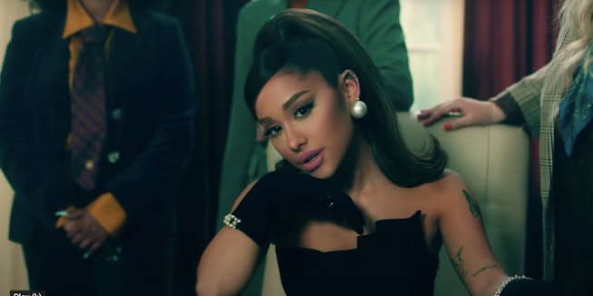 Ariana Grande poses with a pen in her "Positions" video.
