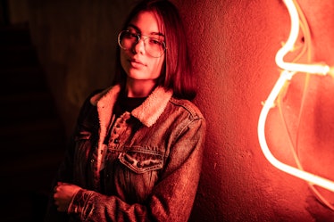 Young woman next to neon light
