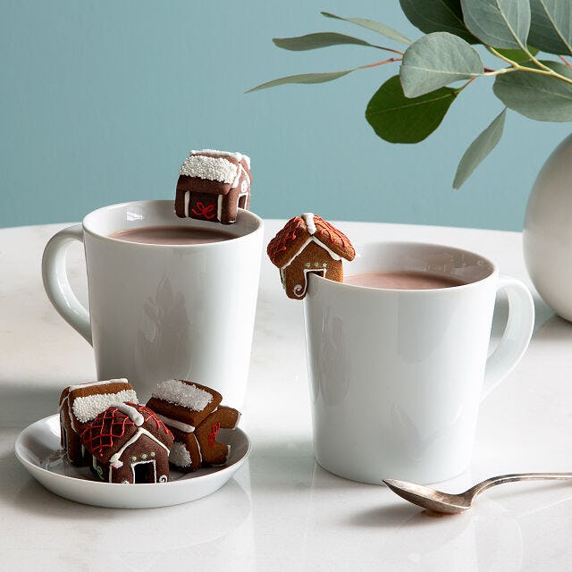 Tiny mug cookies balanced on coffee or cocoa.