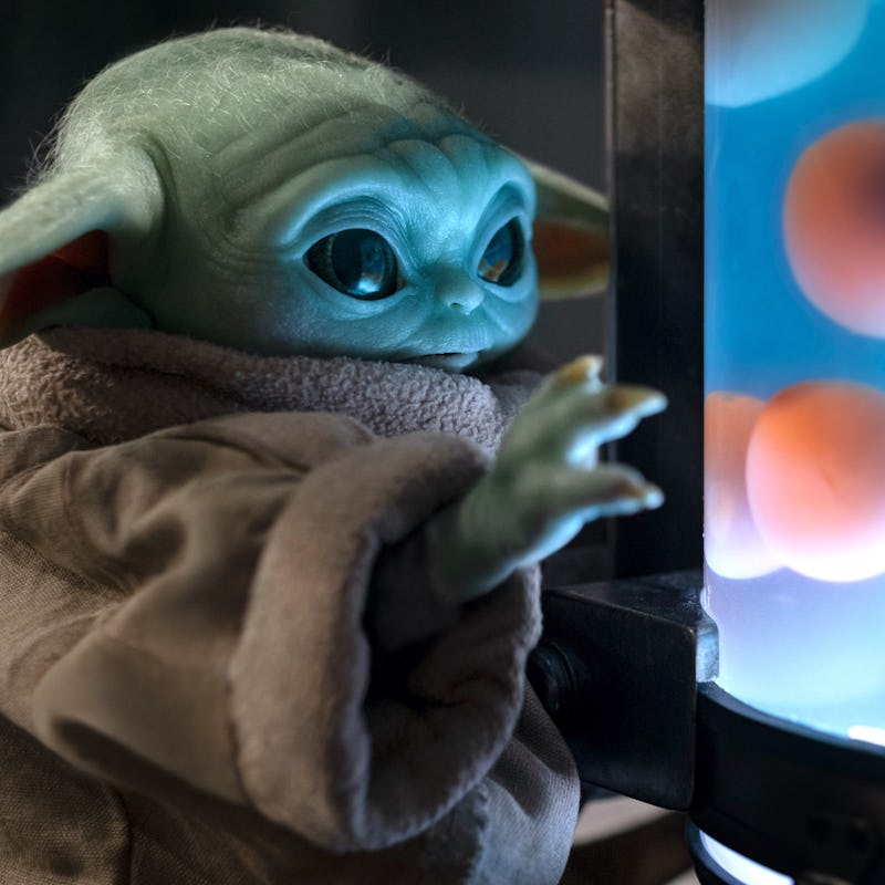 Grogu looking a container with water nd floating round objects in it in the 'Mandalorian' Season 2