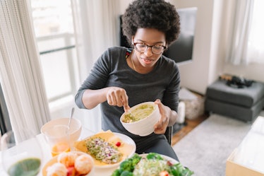 Young woman eating avocado, guacamole