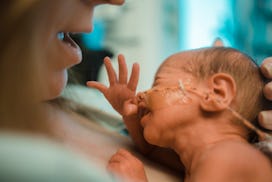 woman holding newborn preemie baby at the hospital