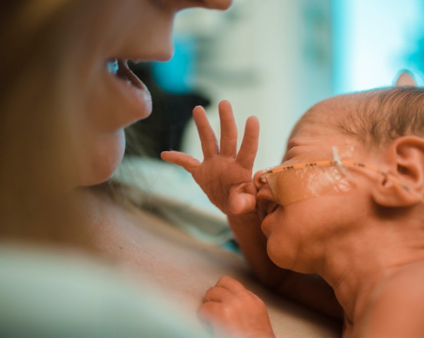 woman holding newborn preemie baby at the hospital