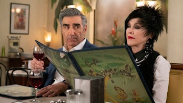 Johnny Rose (Eugene Levy) looks over at Moira Rose (Catherine O'Hara) while sitting at the Cafe Trop...
