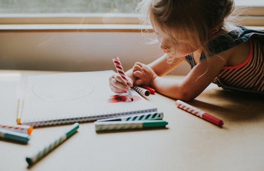 child drawing a picture in her notebook