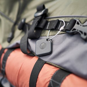 A luggage tracker attached to a khaki green bag
