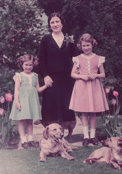 Princess Margaret with Queen Elizabeth with their mother and two dogs in the garden