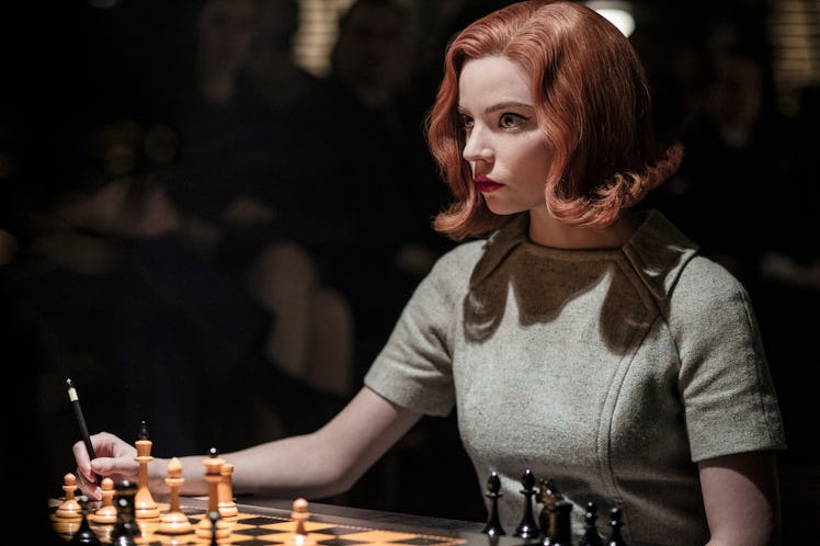 Beth Harmon (Anya Taylor-Joy) stares at her opponent while sitting in front of a chess board in 'The...