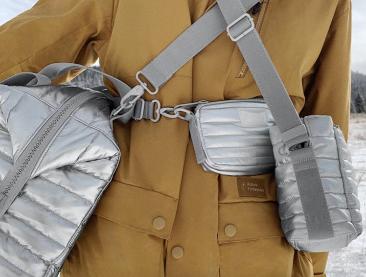 A woman wearing three Dagne Dover bags in the winter stands outside.