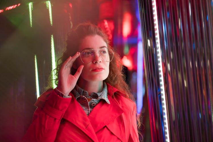 Night portrait of a beautiful young woman with eyeglasses under the colorful neon lights