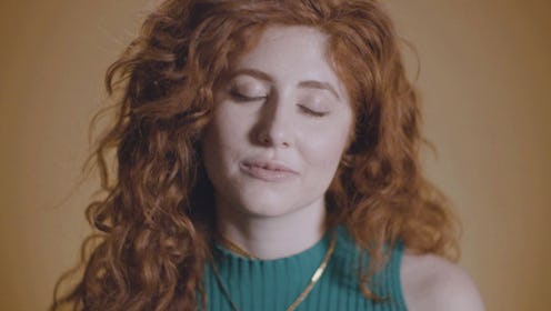 A girl with ginger hair wearing a turquoise shirt