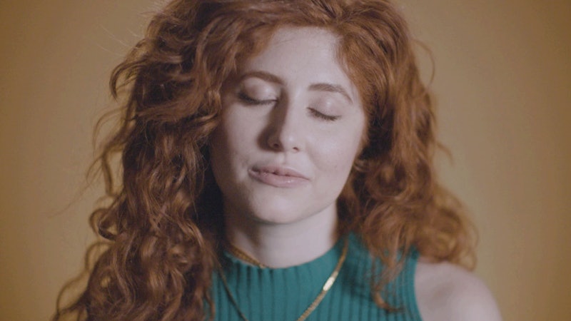 A girl with ginger hair wearing a turquoise shirt 