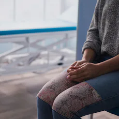 A person sits with her hands in her lap in a medical setting. Doctors explain what to do if you feel...
