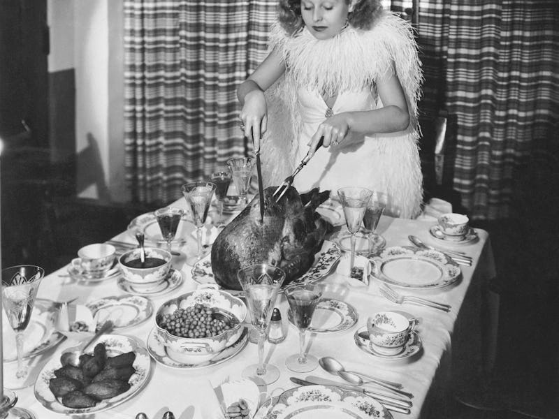 Fox actress Lillian Harvey carves the turkey for a Thanksgiving dinner, Hollywood, California, early...