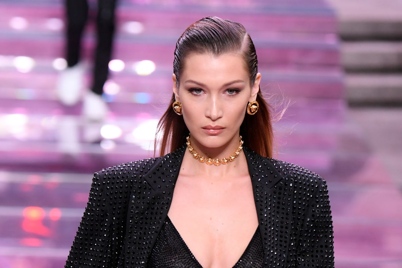 Bella Hadid, with slicked back hair, walks the runway
