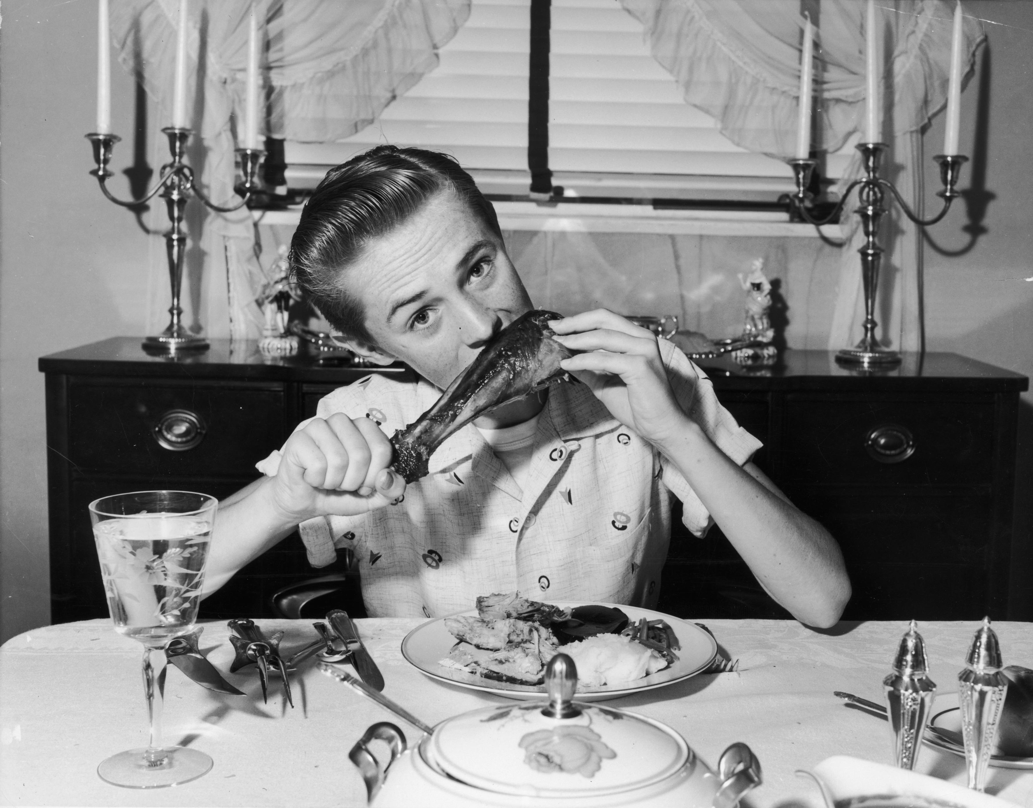 A teenager eats turkey in 1945.
