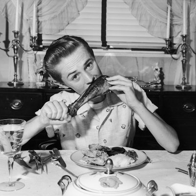 A teenager eats turkey in 1945.