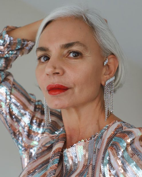 An older lady with grey hair, wearing a sequin party dress and Altalena ear cuffs