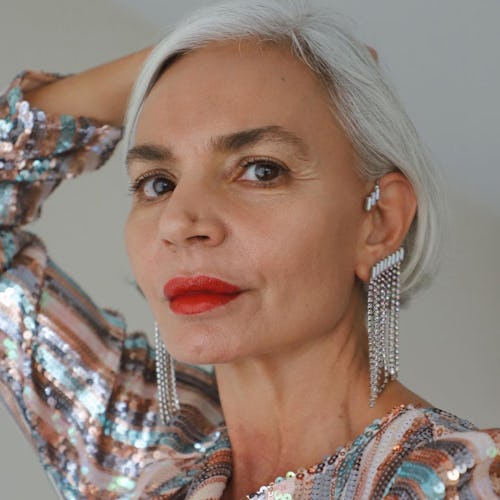 An older lady with grey hair, wearing a sequin party dress and Altalena ear cuffs