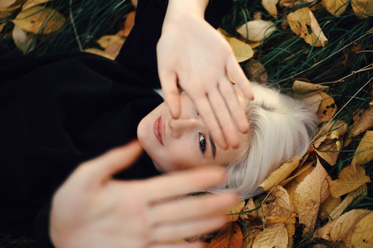 Young Blonde Woman Resting On Orange Leaves