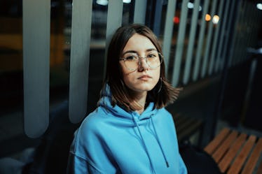 Young woman sitting on the stop at night