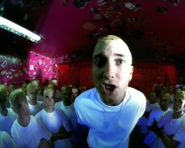 Closeup of rapper Eminem in video for "The Real Slim Shady" with lookalikes surrounding him in the b...
