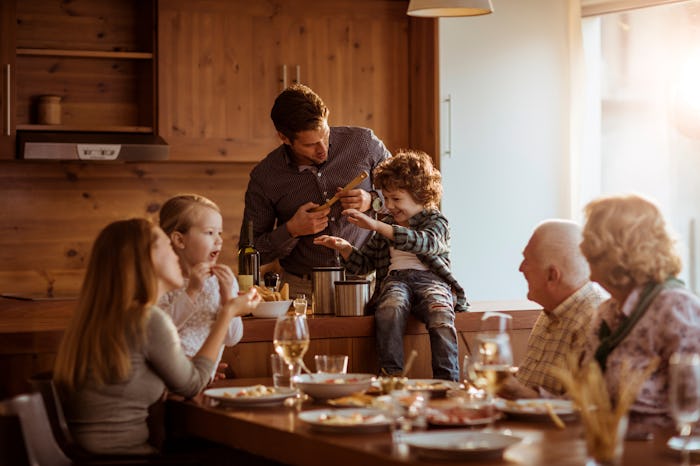 family having thanksgiving dinner indoors with grandparents